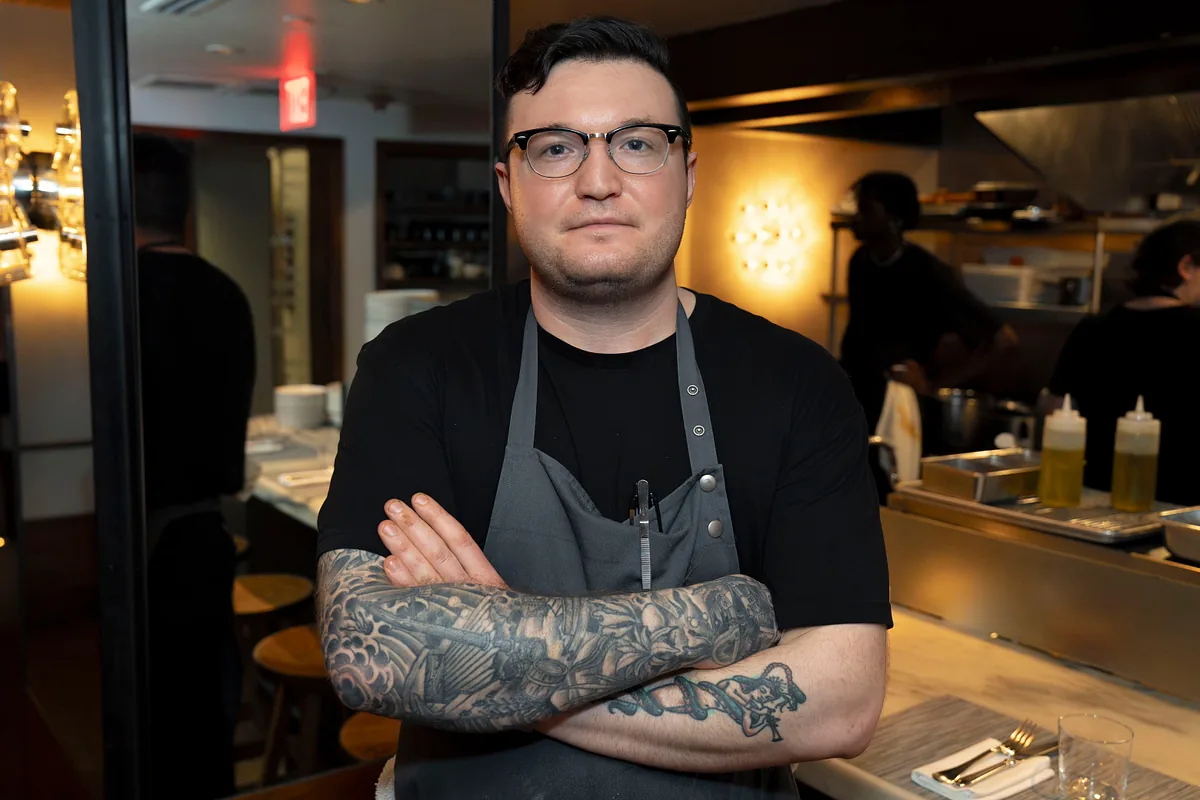 Chef standing with arms folded in the open kitchen