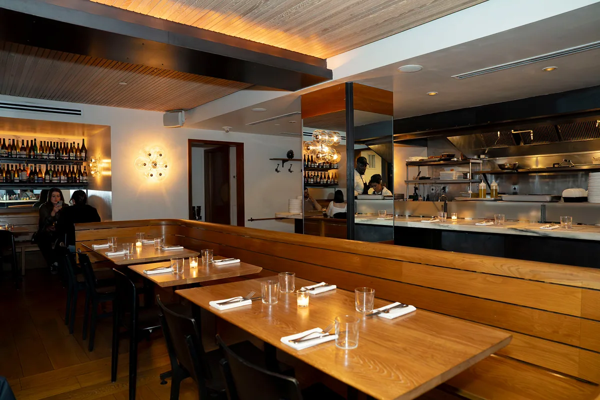 Dining room looking toward the open kitchen, tables set for service