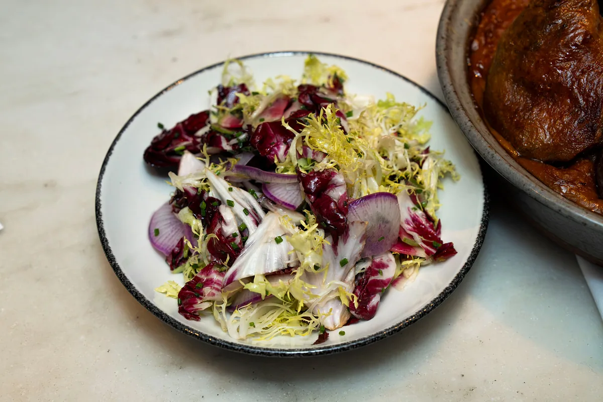 Radicchio and frisee salad in a dark bowl