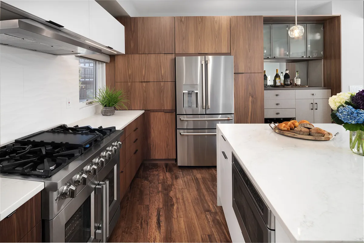 Professional gas range and marble island in a walnut-cabinet kitchen