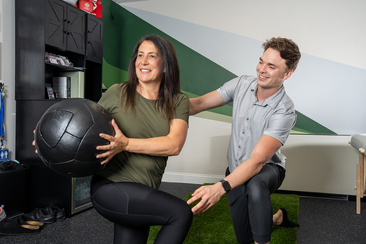 Physical therapist guiding a client through a strength exercise