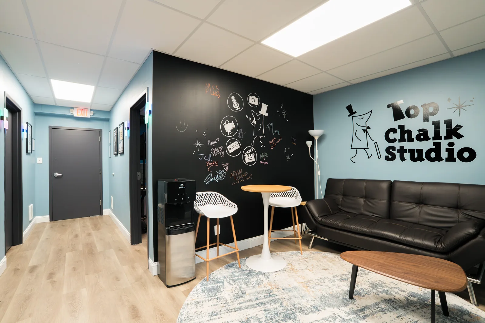 Studio lounge with a chalk-art feature wall, sofa, stools and coffee table