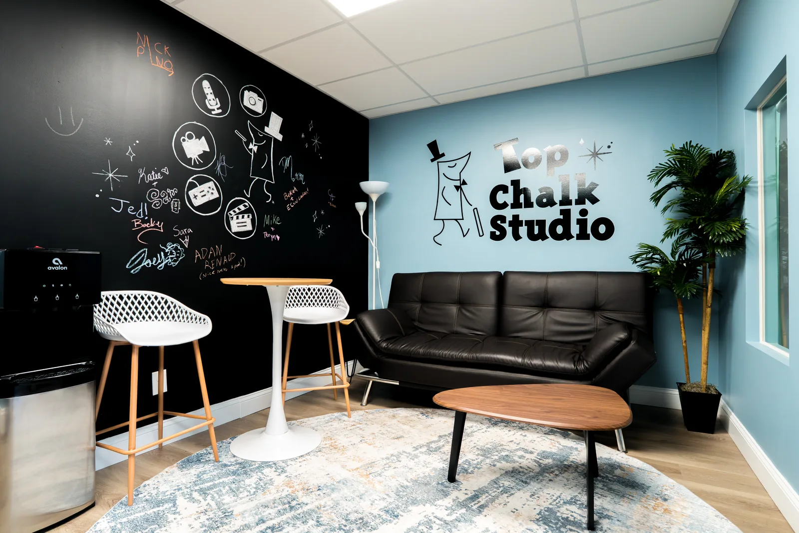 Wide view of the studio lounge and its chalk-art wall