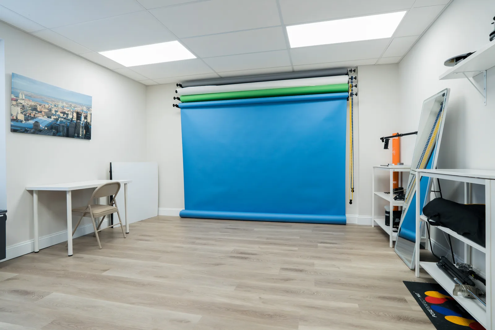 Studio photography bay with a blue seamless backdrop on a roller system